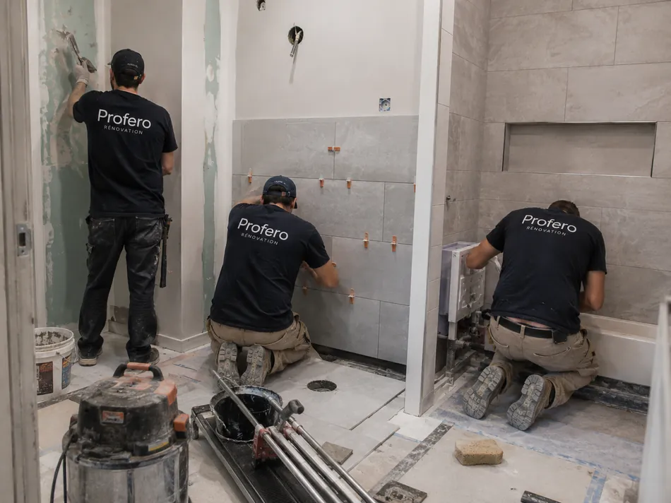 Équipe Profero Rénovation posant du carrelage et aménageant une salle de bain